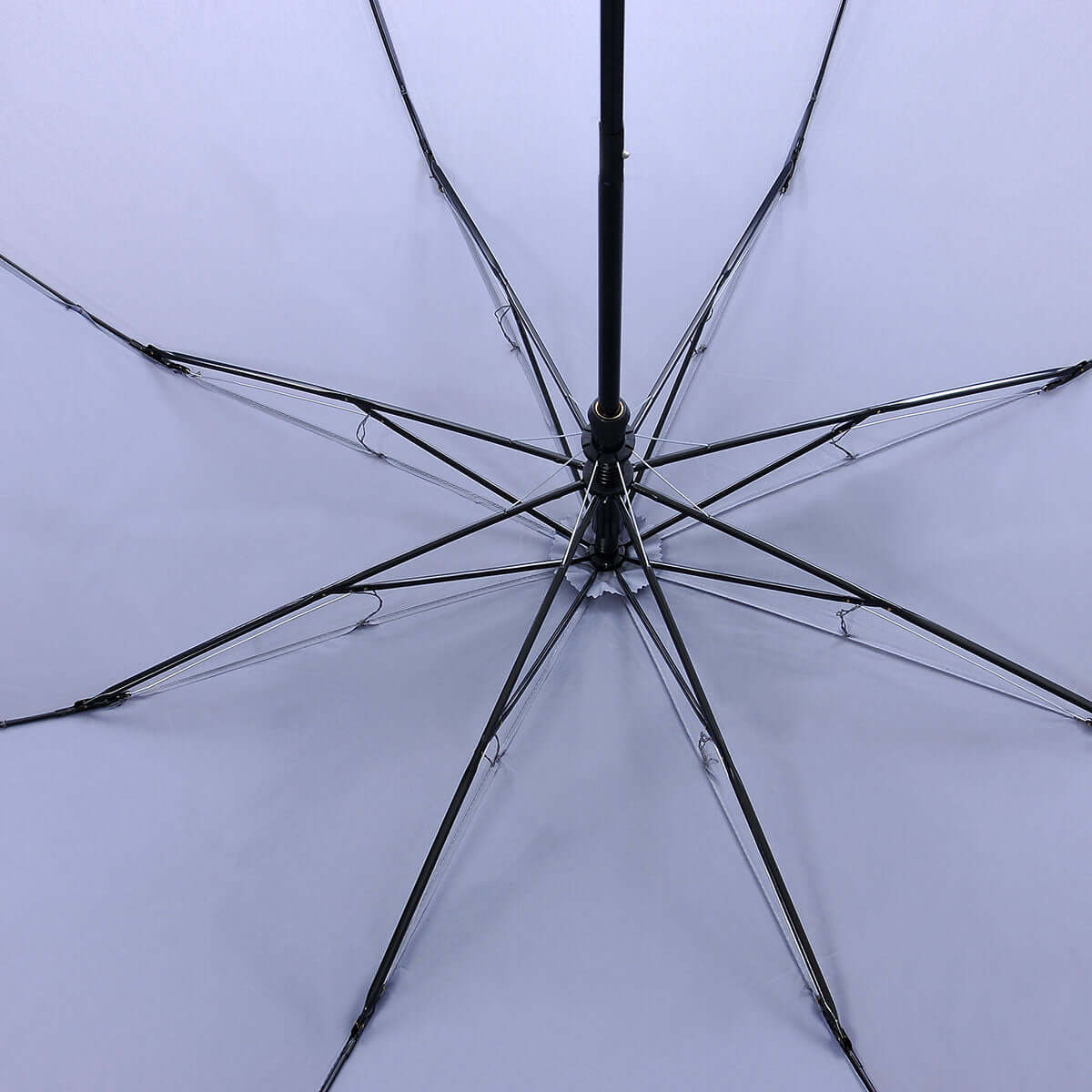 Inside view of the foldable golf umbrella showing the light-colour canopy, black shaft and eight supporting ribs.