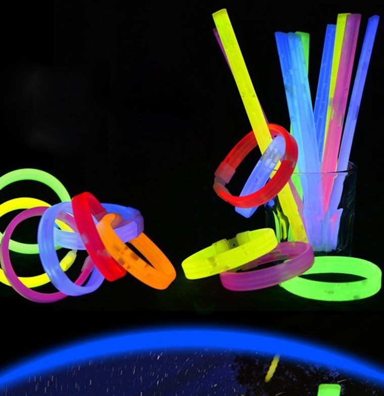 Assorted coloured glowing bracelets and straight glow sticks displayed against a dark background