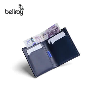 Navy Bellroy Note Sleeve shown open with flat banknotes and cards inside.