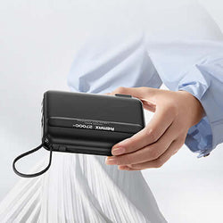 Remax RPP-E7 Fast Charging Powerbank with Wall Plug 27000mAh held in hand, showcasing sleek design and portability.
