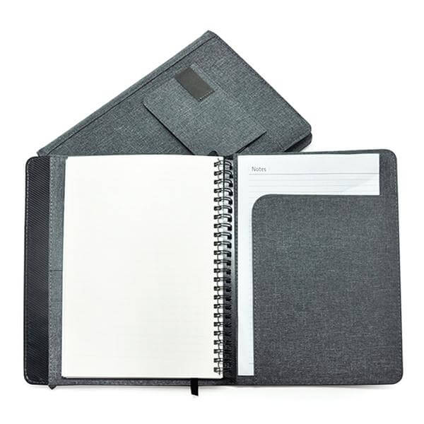 Grey fabric A5 notebook opened to the wire-bound insert and rear document pocket.