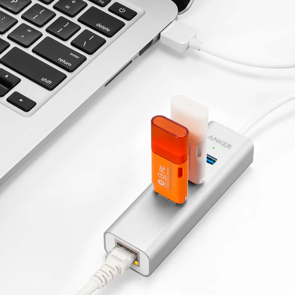 Anker hub connected to a laptop with USB flash drives and an Ethernet cable, shown for illustration.