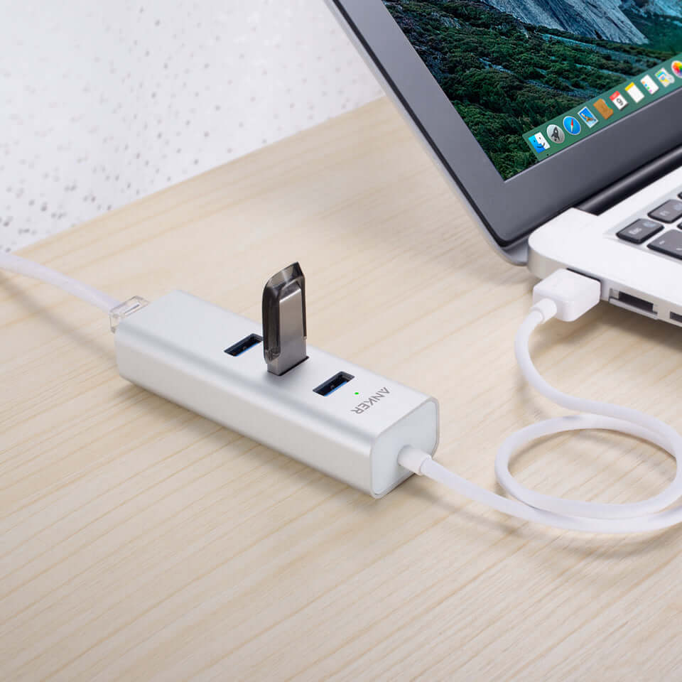 Anker USB and Ethernet hub connected to a laptop with a USB flash drive inserted, shown for illustration.