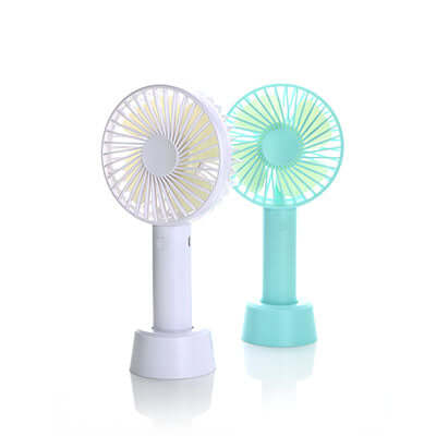 White and turquoise rechargeable portable fans standing in matching detachable bases