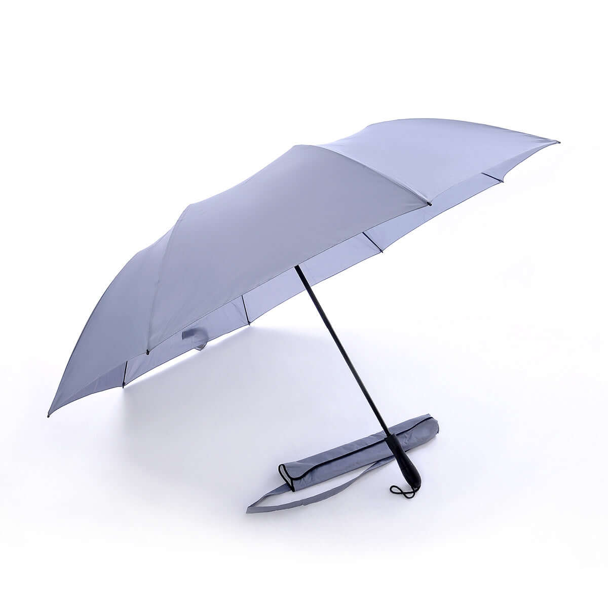 Outer canopy view of the open light-colour golf umbrella beside its carry sleeve with shoulder strap.