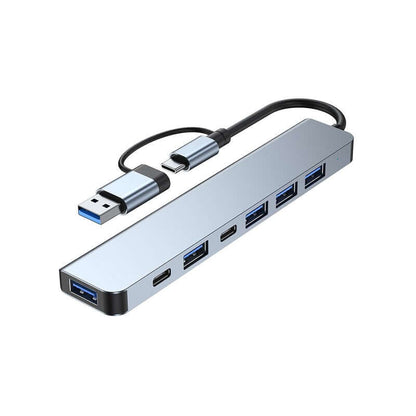 Slim grey seven-port USB hub with USB-A and USB-C ports and a host cable with USB-C plug and USB-A adaptor.