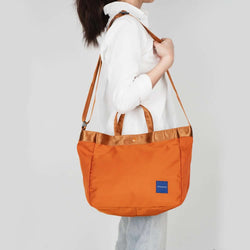Crossing Hollis Anti-Theft RFID Dual Carry Crossbody Bag in orange, showcasing adjustable straps and stylish design.